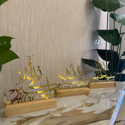 Decorative items with Arabic calligraphy on wooden stands against a neutral wall.