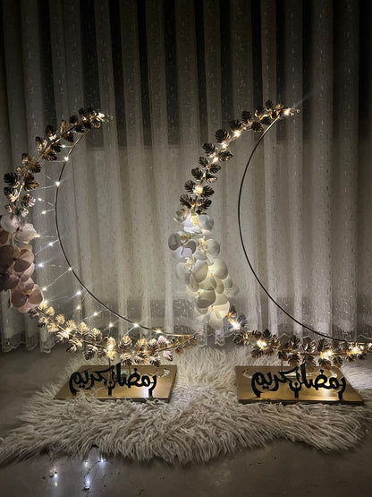 Decorative crescent moon with lights on a fluffy rug against a curtain background