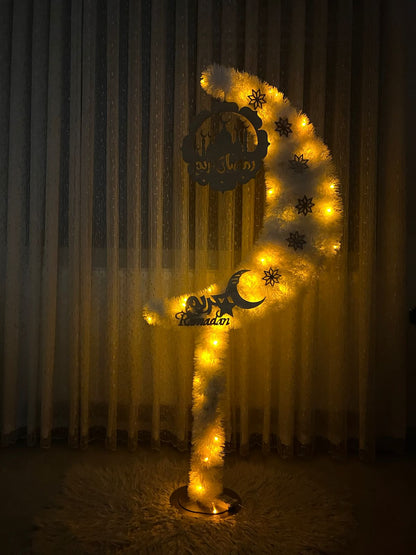Decorative crescent with lights and star patterns against a curtain background