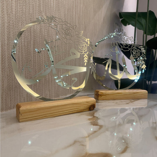 Decorative glass pieces with Arabic calligraphy on wooden stands against a neutral background