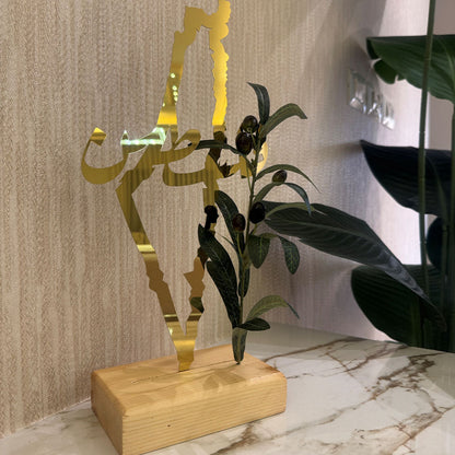 Gold decorative item with plant on a marble surface