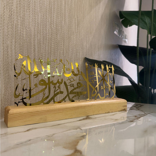 Decorative piece with Arabic calligraphy on a wooden base against a neutral wall.